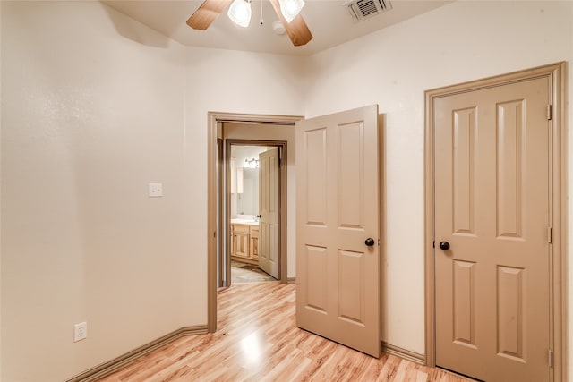 unfurnished bedroom featuring light hardwood / wood-style floors, ensuite bathroom, and ceiling fan