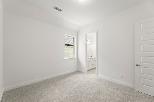 carpeted spare room with vaulted ceiling