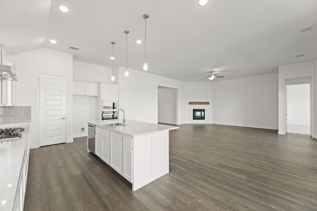 kitchen featuring white cabinetry, sink, a center island with sink, and decorative light fixtures