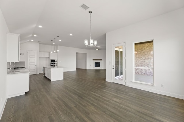 kitchen featuring decorative light fixtures, white cabinets, a kitchen island with sink, and dark hardwood / wood-style floors