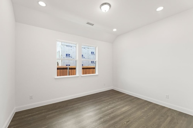 empty room with dark hardwood / wood-style flooring and lofted ceiling