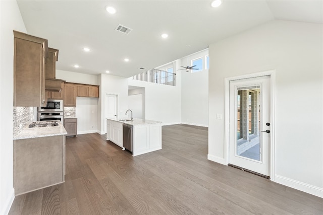 kitchen with dark wood-style flooring, visible vents, appliances with stainless steel finishes, a sink, and light stone countertops