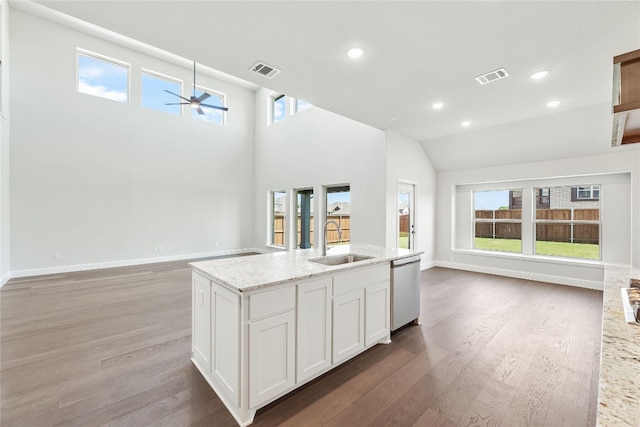 kitchen with stainless steel dishwasher, visible vents, open floor plan, and a sink