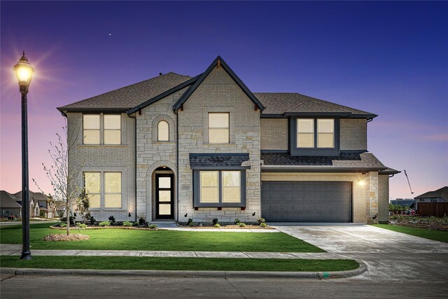 view of front of home with a garage, a shingled roof, concrete driveway, a front lawn, and brick siding