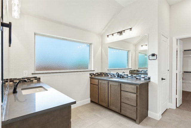 full bathroom featuring lofted ceiling, two vanities, a sink, and decorative backsplash