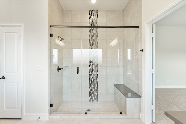 bathroom with a stall shower and baseboards