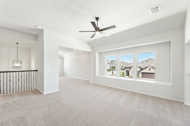 carpeted spare room with ceiling fan with notable chandelier, lofted ceiling, visible vents, and baseboards