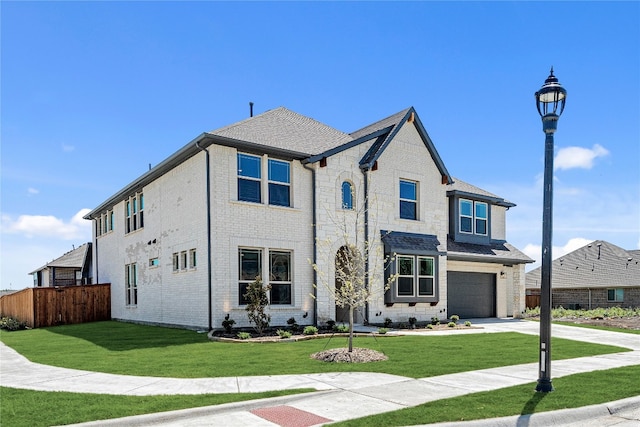 view of front facade featuring a garage, driveway, a front lawn, and fence