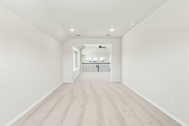 unfurnished living room with lofted ceiling, visible vents, light carpet, and baseboards