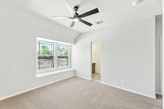 empty room featuring baseboards, visible vents, a ceiling fan, light colored carpet, and lofted ceiling