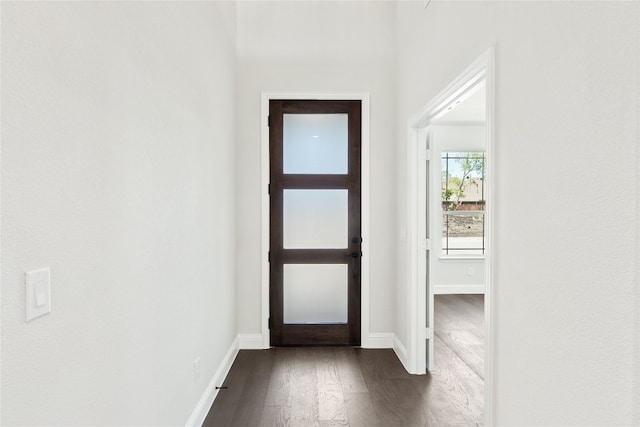 entryway with dark wood finished floors and baseboards