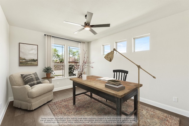 office space with dark wood-style flooring, a ceiling fan, and baseboards