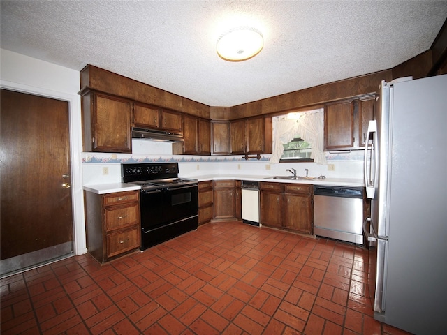 1505 S Rodgers Dr, Graham, TX 76450 - kitchen featuring appliances with stainless steel finishes, under cabinet range hood, brick patterned floors, a sink, and light countertops