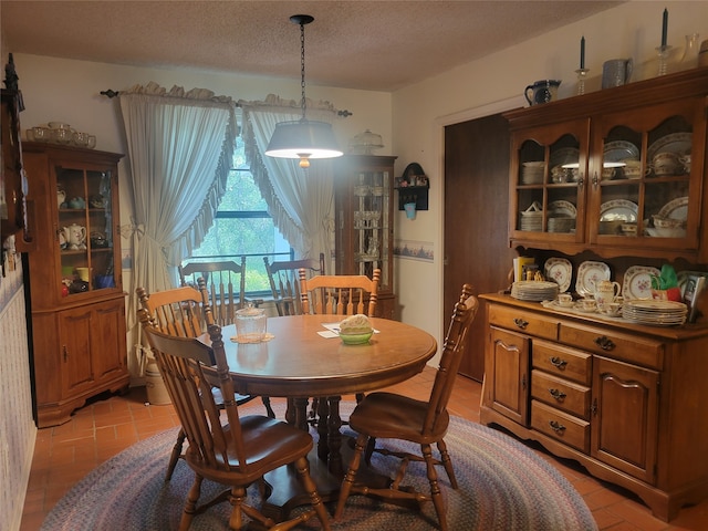 tiled dining space with a textured ceiling