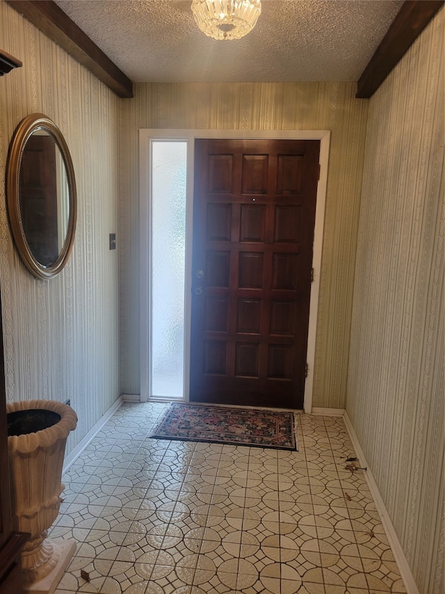 foyer with wood walls and a textured ceiling