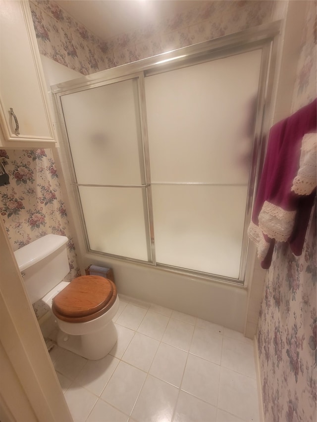 bathroom featuring shower / bath combination with glass door, toilet, and tile patterned floors