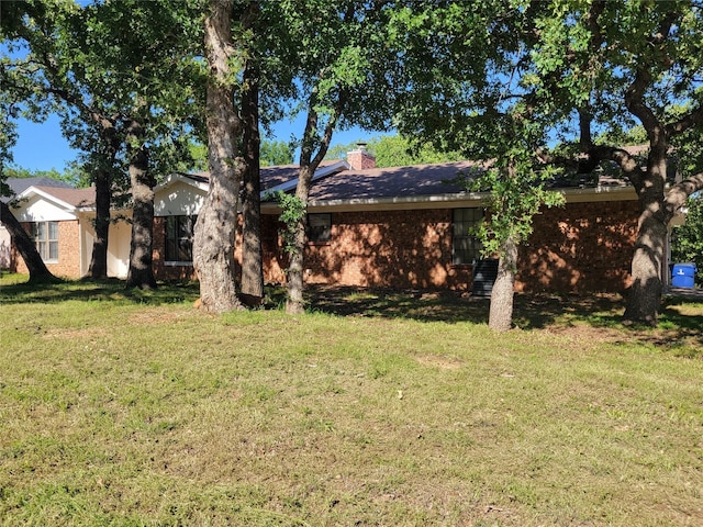 1505 S Rodgers Dr, Graham, TX 76450 - rear view of property with a lawn and a chimney