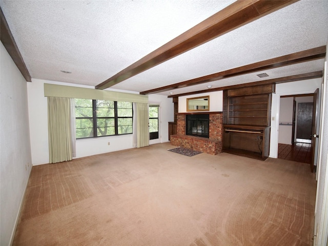 1505 S Rodgers Dr, Graham, TX 76450 - unfurnished living room with a textured ceiling, carpet flooring, beam ceiling, and a brick fireplace