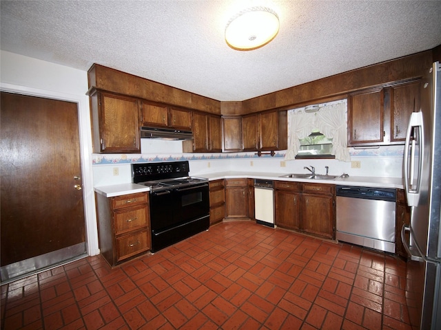 1505 S Rodgers Dr, Graham, TX 76450 - kitchen with appliances with stainless steel finishes, under cabinet range hood, brick patterned floors, light countertops, and a textured ceiling