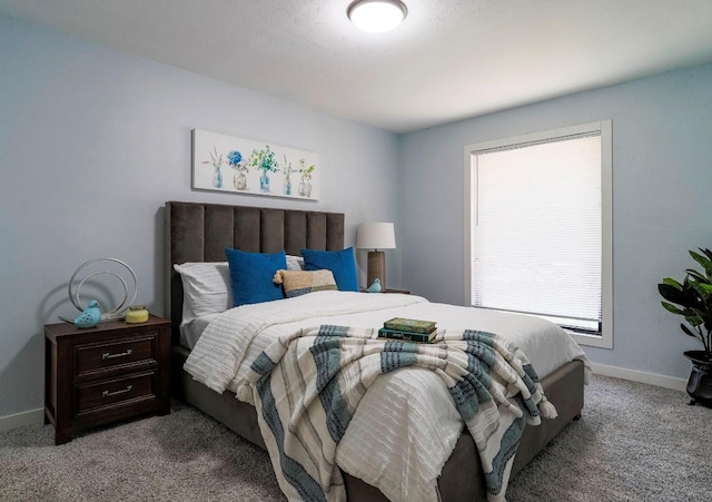 bedroom featuring dark colored carpet and multiple windows