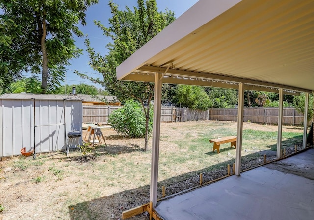 view of yard featuring a shed and a patio area