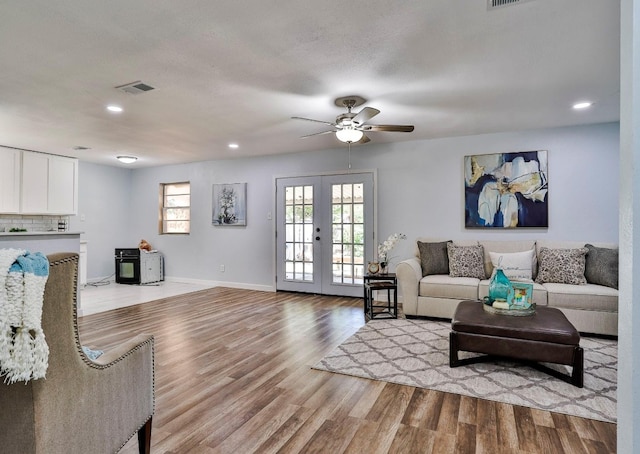 living room featuring french doors, light hardwood / wood-style floors, and ceiling fan