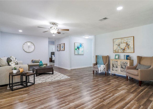 living room featuring ceiling fan and dark wood-type flooring