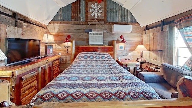 bedroom featuring a wall mounted AC, lofted ceiling, a barn door, and wooden walls