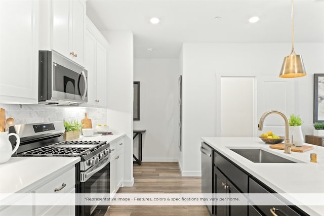 kitchen featuring light hardwood / wood-style flooring, backsplash, sink, white cabinets, and appliances with stainless steel finishes