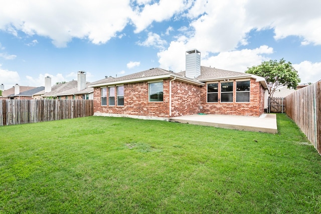 back of property with a yard and a patio