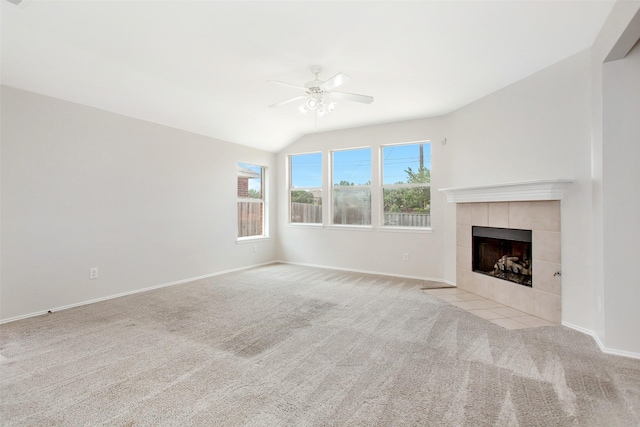 unfurnished living room featuring a tile fireplace, light colored carpet, ceiling fan, and lofted ceiling