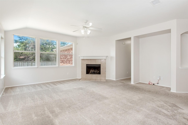 unfurnished living room featuring ceiling fan, light colored carpet, lofted ceiling, and a tile fireplace