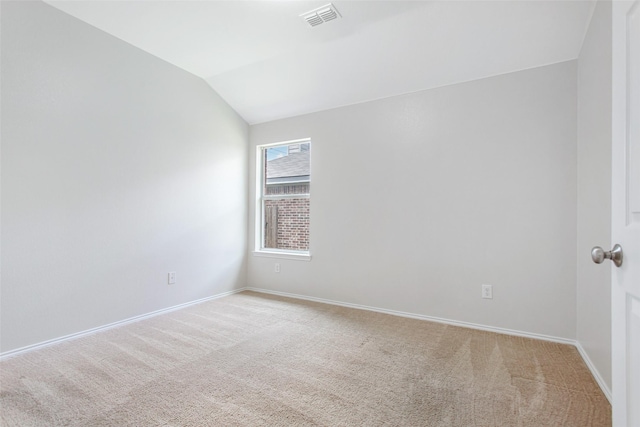 carpeted spare room featuring lofted ceiling