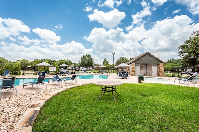 view of swimming pool with a lawn, an outbuilding, a patio, and grilling area