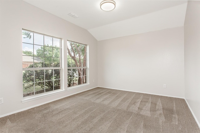 spare room featuring carpet floors and vaulted ceiling