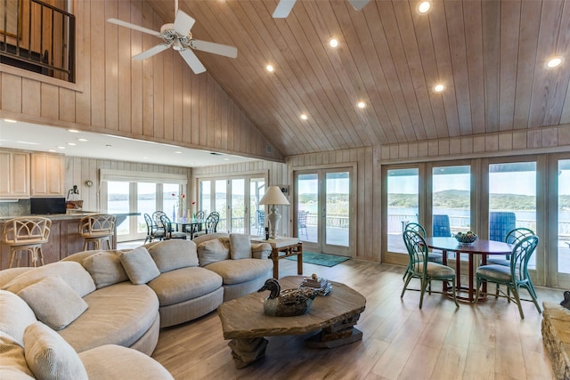 living room with ceiling fan, french doors, high vaulted ceiling, and light hardwood / wood-style floors