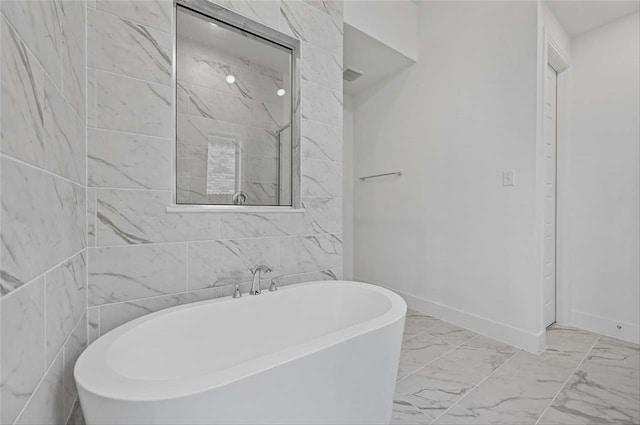 bathroom with tile patterned flooring, a bath, and tile walls