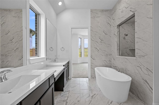 bathroom featuring dual vanity, tile patterned flooring, lofted ceiling, and tile walls