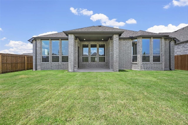 back of property with a patio area and a yard