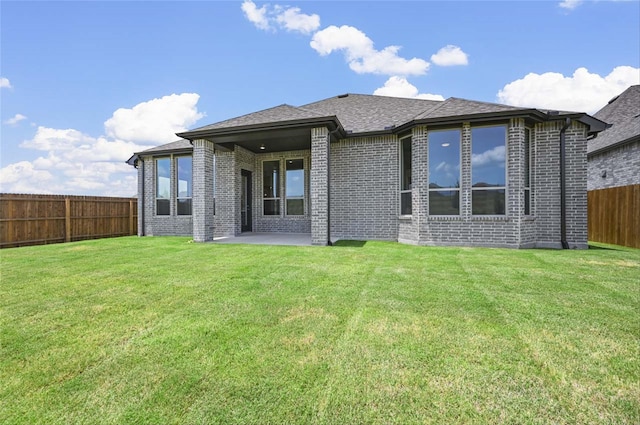 back of property with a patio and a yard