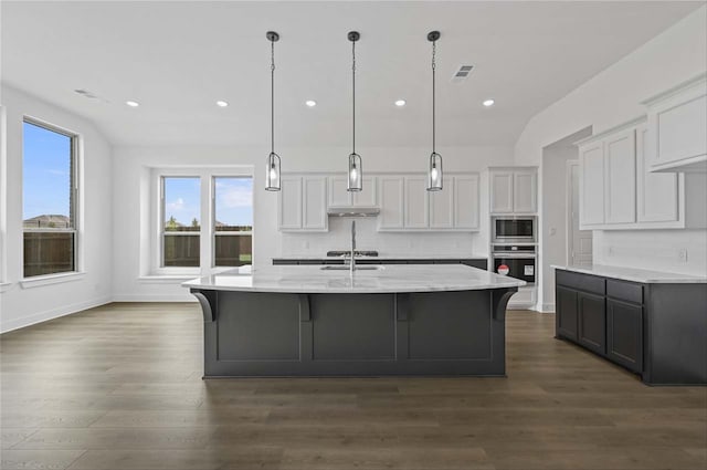 kitchen with white cabinets, wood-type flooring, and appliances with stainless steel finishes