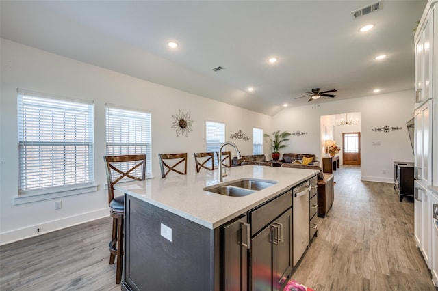 kitchen with visible vents, light wood-style flooring, a kitchen island with sink, a sink, and recessed lighting