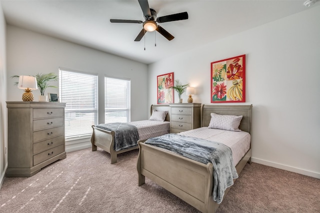 bedroom with light carpet, baseboards, and a ceiling fan