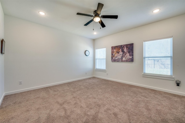 carpeted empty room featuring recessed lighting, plenty of natural light, and baseboards