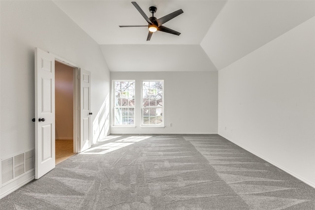 spare room featuring ceiling fan, light colored carpet, and vaulted ceiling