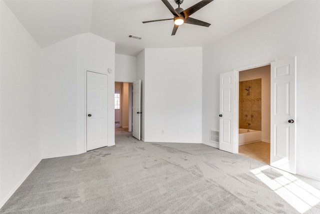 unfurnished bedroom with ceiling fan, lofted ceiling, ensuite bathroom, and light colored carpet