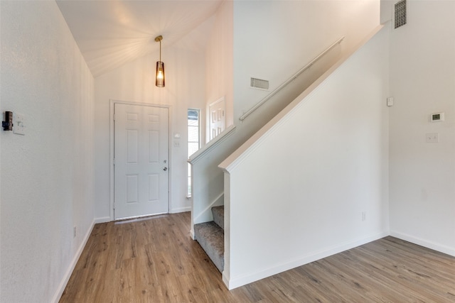 foyer entrance featuring high vaulted ceiling and light hardwood / wood-style floors