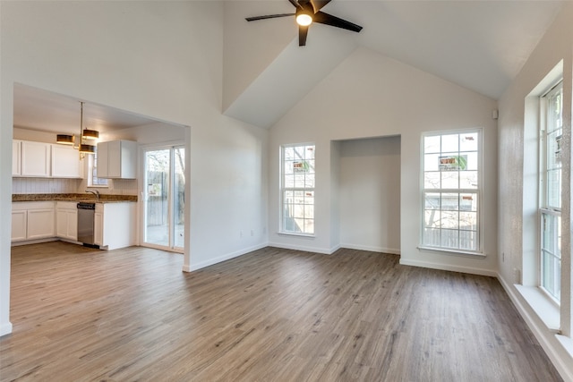 unfurnished living room featuring ceiling fan, light wood-type flooring, and a wealth of natural light