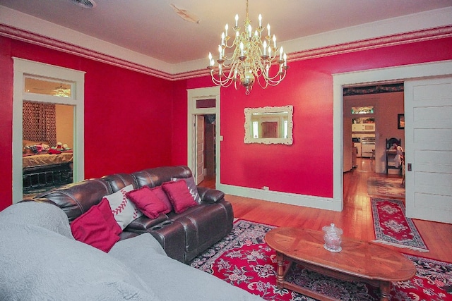 living room featuring an inviting chandelier, hardwood / wood-style floors, and crown molding