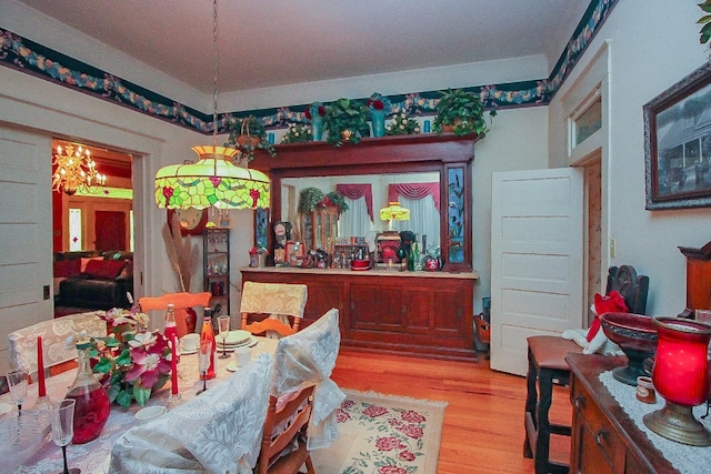 dining space with light hardwood / wood-style flooring and a chandelier